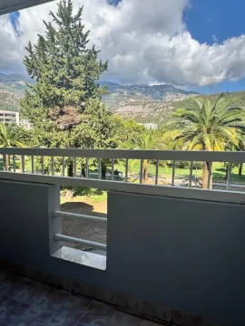 View from the terrace overlooking green areas and mountains. - image 2