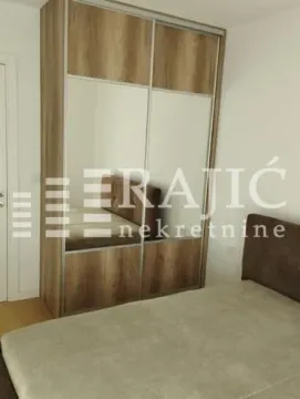Bedroom with a bed and a large wardrobe. - image 10