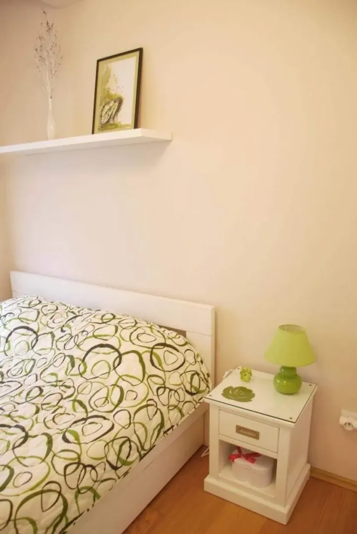 Uređena spavaća soba sa krevetom i noćnim stočićem.