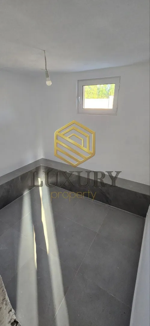 Empty room with a window and tiled floor.