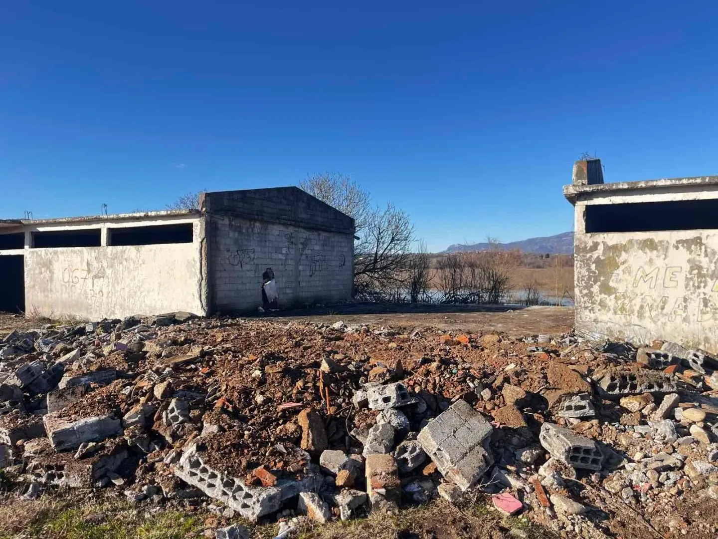 Pogled na ruinirani objekat sa gomilom šuta i ruševina u prvom planu.
