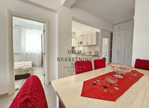 Living room with a dining table and a view of the kitchen. - image 7