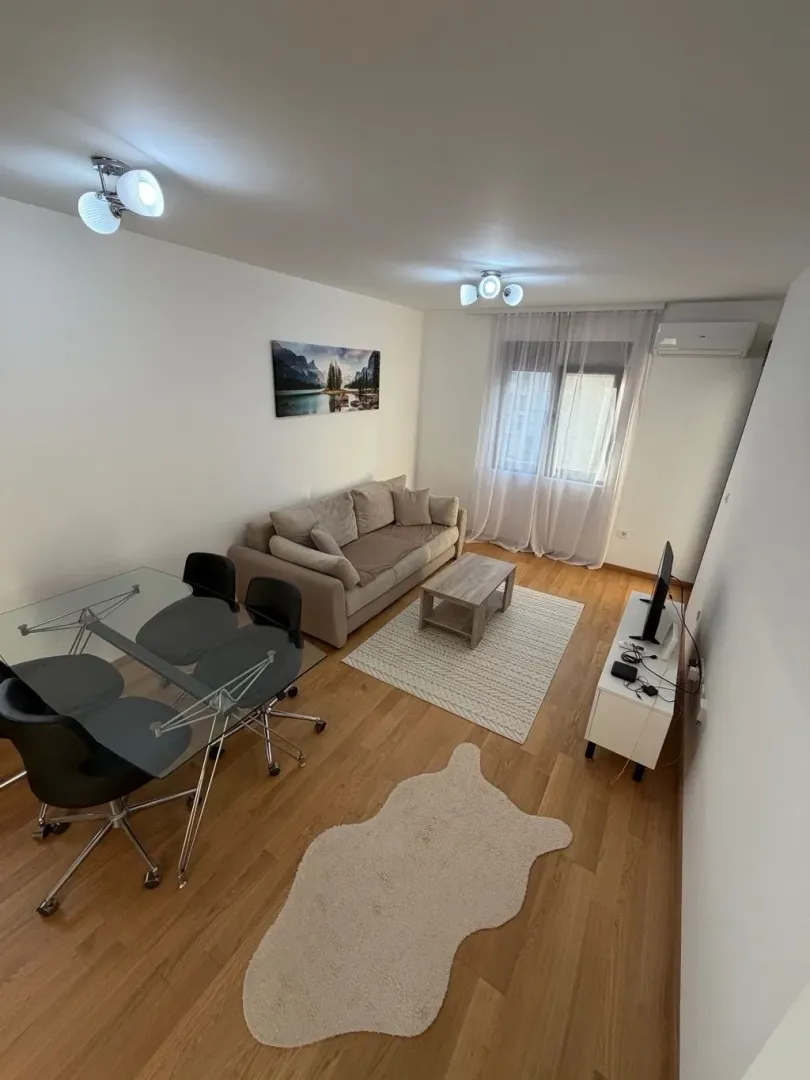 Living room with a sofa, dining table and TV unit.