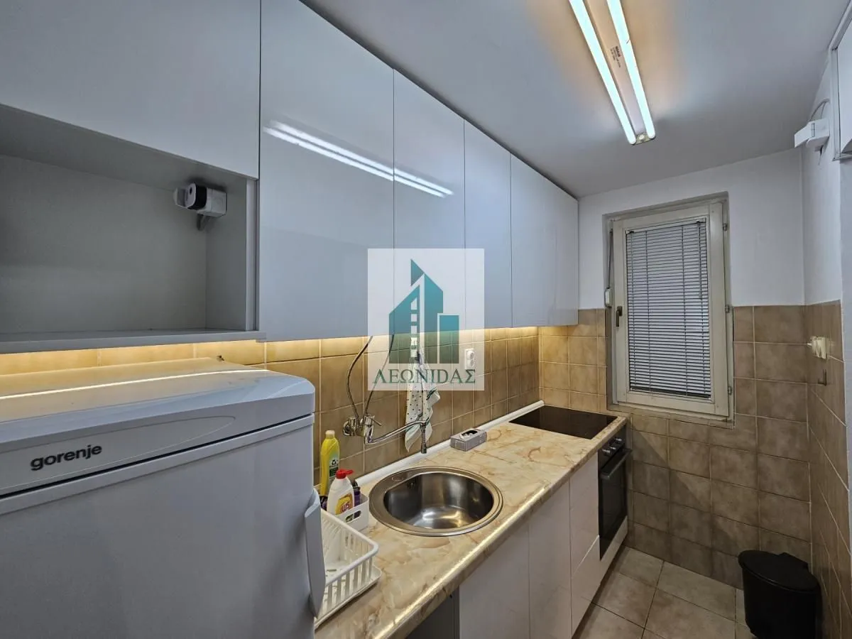 Small kitchen with white cabinets, a sink, and a built-in hob.