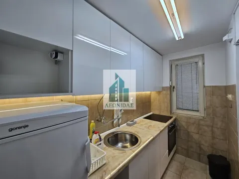Small kitchen with white cabinets, a sink, and a built-in hob. - image 4