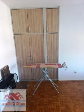 Room with a built-in wardrobe, ironing board, and fan. - image 17