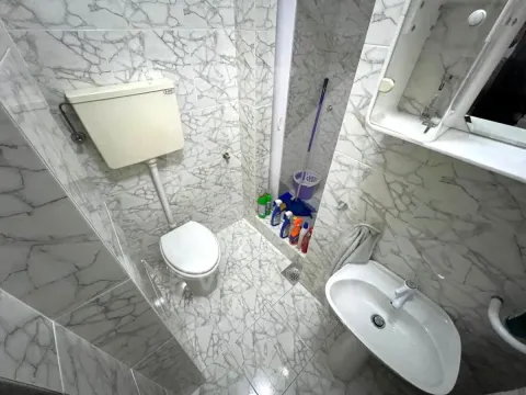 Manje kupatilo obloženo mermernim pločicama sa WC šoljom, umivaonikom i tuš kabinom. - image 9