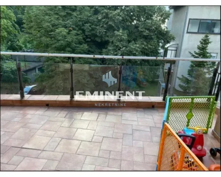 Spacious tiled terrace with a railing and a view of greenery. - image 15