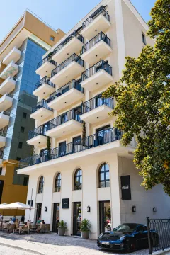 Exterior view of a modern residential building with balconies and ground floor commercial space. - image 4