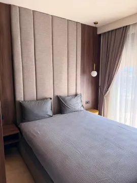 Modern bedroom with a double bed, upholstered headboard, and wooden wall panels. - image 10