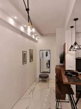 Modern kitchen with a bar counter and dining table. - image 8