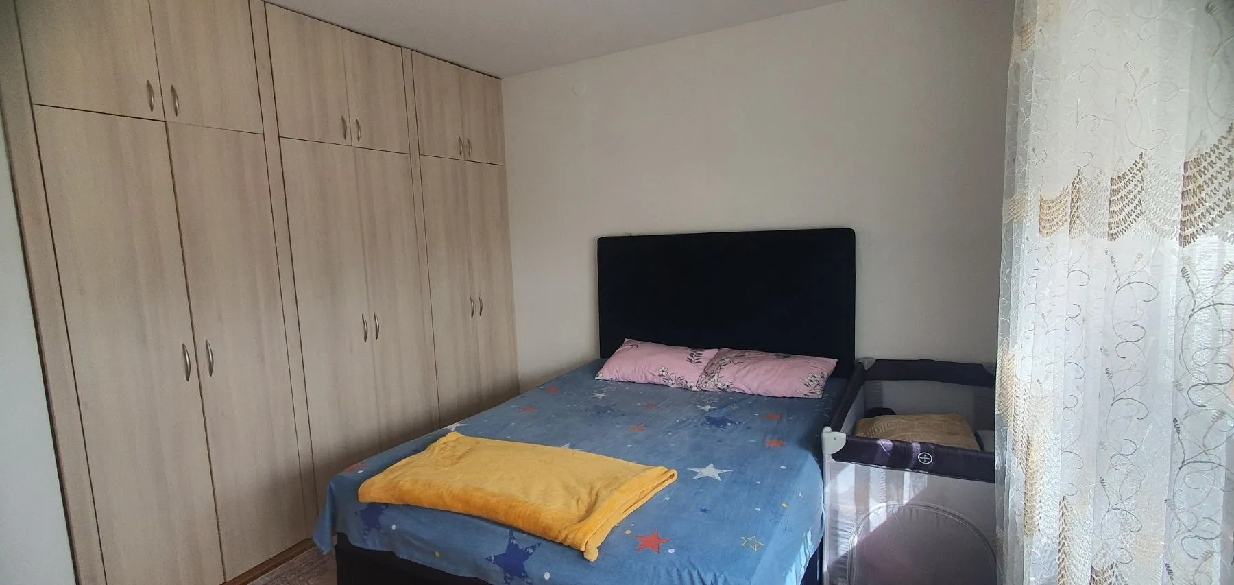Spavaća soba sa bračnim krevetom, plakarom i dječijim krevecom.