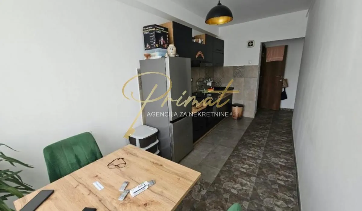Small kitchen with a dining table and black kitchen units.
