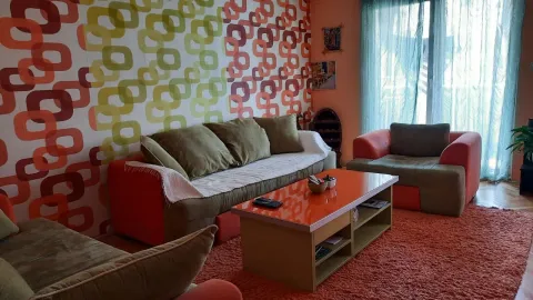 A living room featuring retro patterned wallpaper, comfortable seating, and an orange coffee table. - image 14