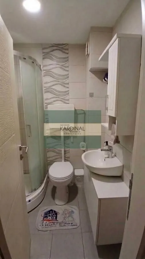 Manje kupatilo sa tuš kabinom, umivaonikom i wc šoljom.