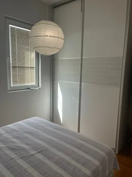 Bedroom with a bed, large wardrobe, and a window with blinds. - image 9