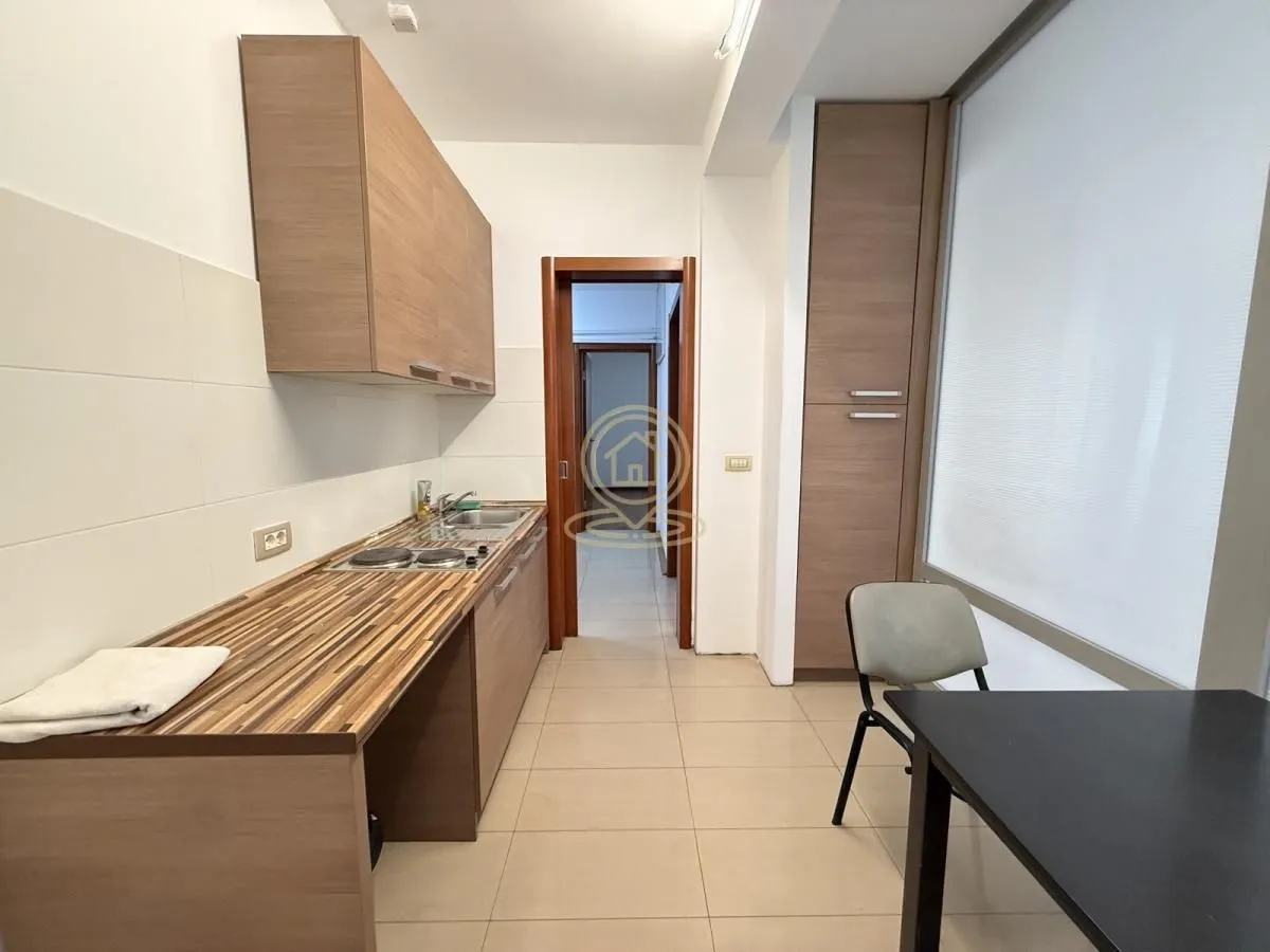 Small kitchen with wooden cabinetry and a dining table.