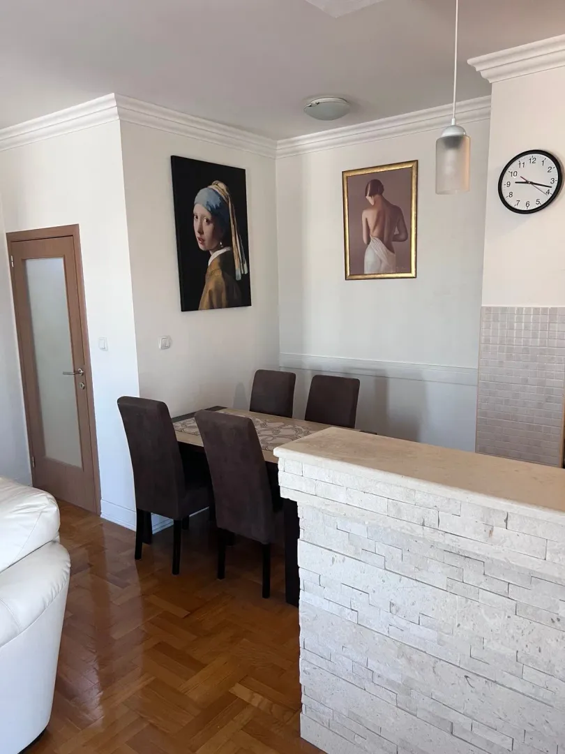 Trpezarija sa trpezarijskim stolom i stolicama u sklopu dnevnog boravka.