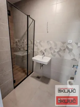 Novoopremljeno kupatilo sa tuš kabinom, umivaonikom i pločicama. - image 7