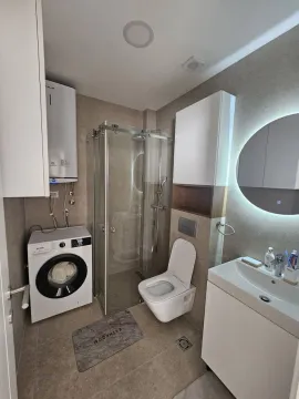 Moderno opremljeno kupatilo sa tuš kabinom, veš mašinom i umivaonikom. - image 3