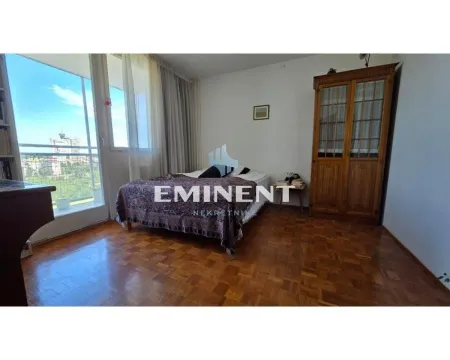 Nameštena spavaća soba sa bračnim krevetom, drvenim ormarom i izlazom na balkon. - image 4