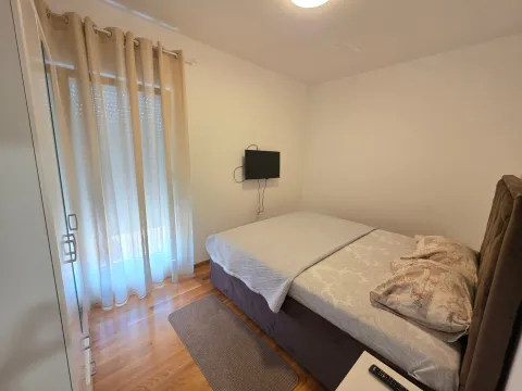 Namještena spavaća soba sa bračnim krevetom i televizorom na zidu. - image 4