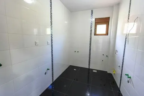 Nedovršeno kupatilo sa bijelim zidnim pločicama i tamnim podom. - image 9