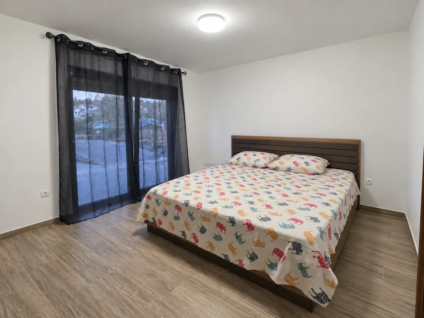 Bedroom with a double bed and balcony doors.