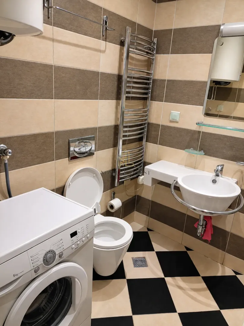 Kupatilo opremljeno sanitarijama, umivaonikom, wc šoljom i veš mašinom.