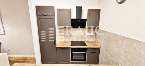 View of a kitchen section with grey cabinets and a built-in oven. - image 5