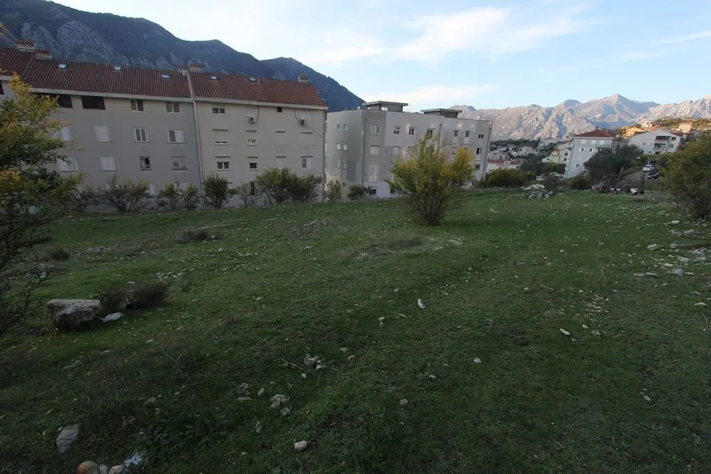 Zemljišna parcela sa pogledom na okolne zgrade i planine.