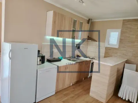 Kitchen equipped with wooden cabinets, white goods, and a breakfast bar. - image 4
