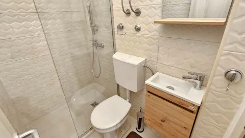 Manje kupatilo sa tuš kabinom, WC šoljom i umivaonikom sa ormarićem. - image 6
