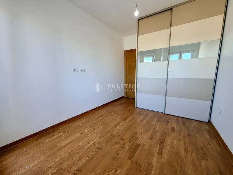 Prazna spavaća soba sa ugradnim plakarom i drvenim podom.