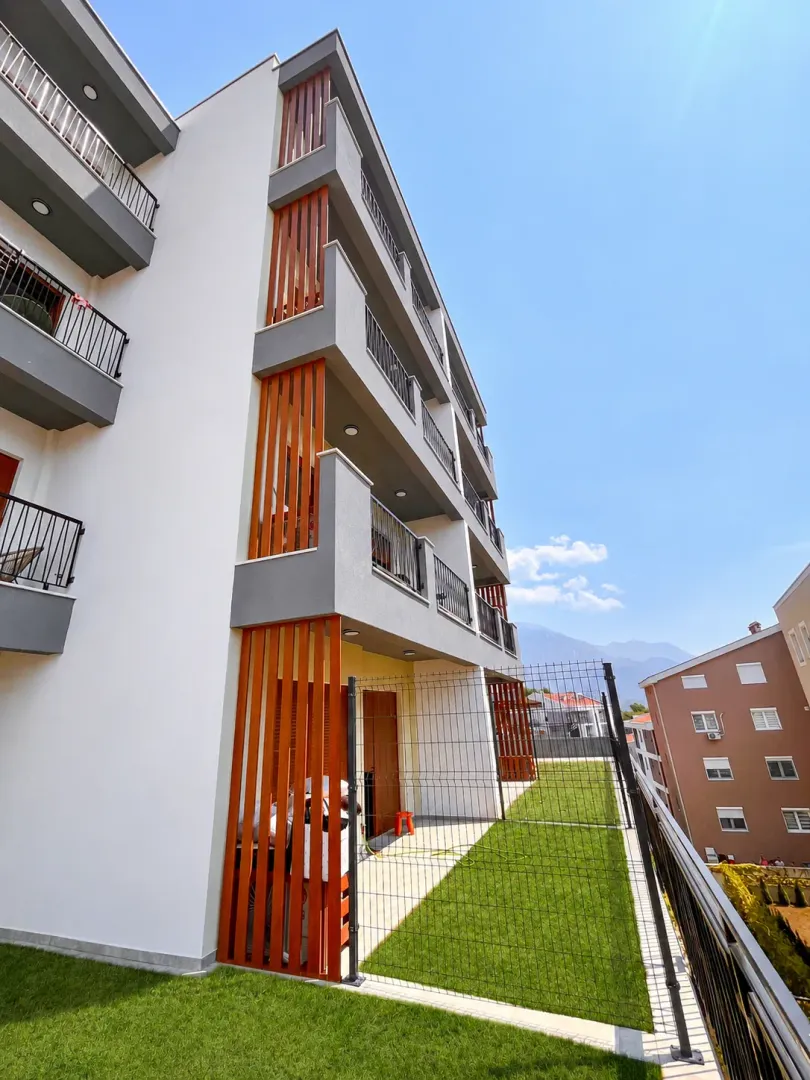 Spoljašnji izgled moderne stambene zgrade sa terasama i dvorištem.