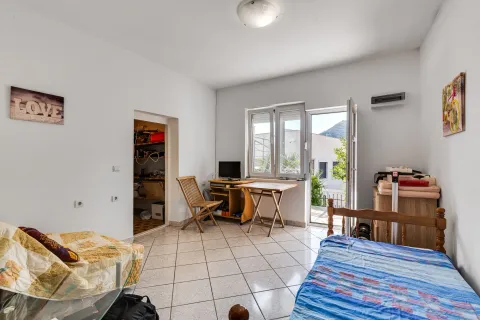 Manja spavaća soba sa krevetom, stolom i izlazom na terasu. - image 13