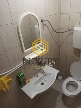 Small bathroom with a sink, mirror, and toilet. - image 9