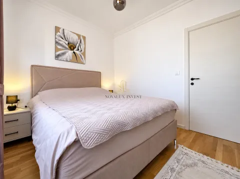 Furnished bedroom with a double bed, nightstand, and a painting on the wall. - image 10