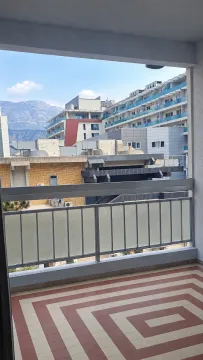 Pogled sa balkona na okolne zgrade i planine. - image 4