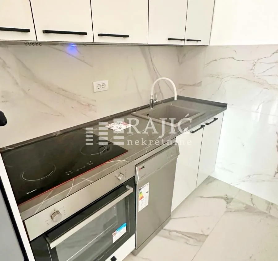 Modern kitchen with built-in cooktop, oven, dishwasher, and sink.