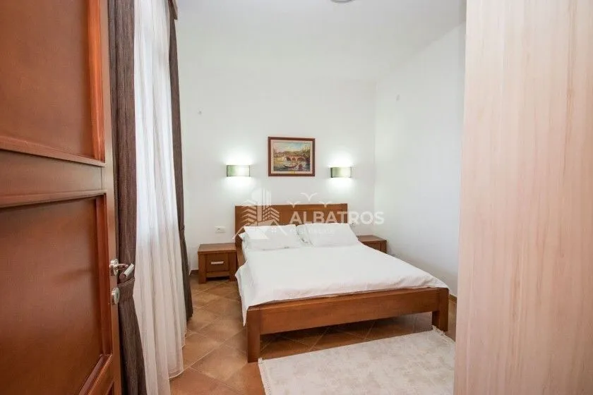 Bedroom with a double bed, nightstands, and a window with curtains.