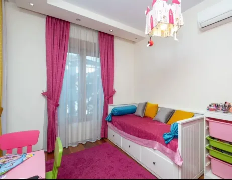 Children's bedroom with a bed, pink curtains, and a rug. - image 8
