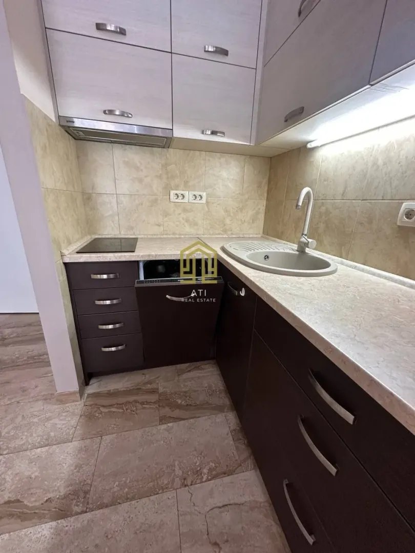 Small modern kitchen with dark and light cabinetry.
