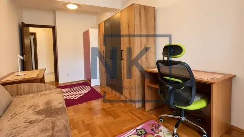 Furnished bedroom with a bed, desk, and large wardrobe. - image 11
