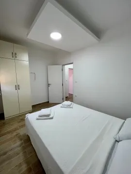 Bedroom with a double bed, wardrobe, and white linens. - image 6