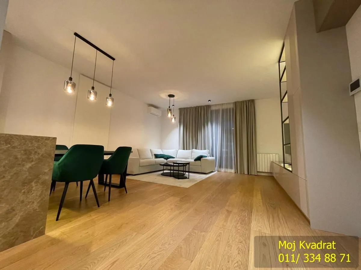 Living room with dining area and modern lighting.