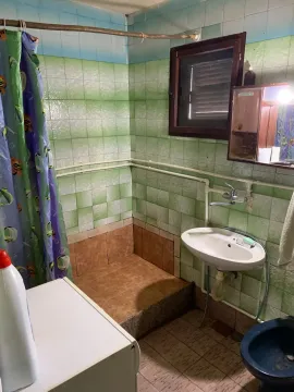 Manje kupatilo sa tuš-kabinom, umivaonikom i zelenim pločicama. - image 12