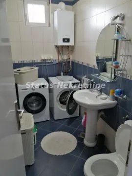 Kupatilo opremljeno sanitarijama, umivaonikom, WC šoljom i mašinama za pranje i sušenje veša. - image 8