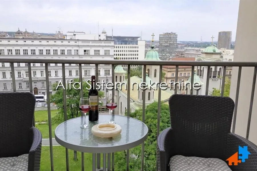 Balkon sa garniturom za sedenje i pogledom na grad.