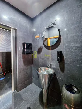 Modernly equipped bathroom with dark tiles and a metal washbasin. - image 16